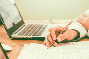 Notebook, Hand mit Bleistift, Notizen auf Zettel