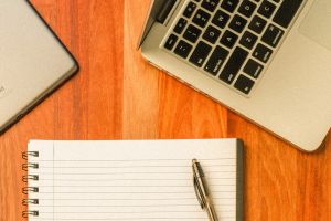 Block mit Kugelschreiber und Notebook