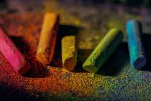 5 Kreiden mit Kreidenstaub: rosa, orange, gelb, grün und blau