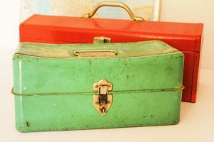 Grüne und rote geschlossene, metallene Werkzeugkisten