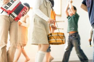 Kinder mit Musikinstrumenten (AkKordeon, Trommel) gehen im Kreis spazieren