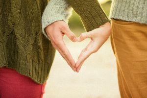 Zwei Hände unterschiedlicher Personen bilden ein Herz